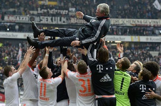 Bayern players lift headcoach Jupp Heynckes after winning the Bundesliga match in Frankfurt on April 6, 2013